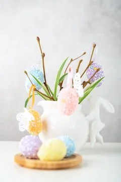Home interior with easter decor. Vase with willow tree branches with Easter eggs Stock Photos