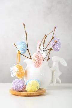 Home interior with easter decor. Vase with willow tree branches with Easter eggs Stock Photos