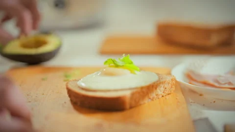 In home kitchen chefs skilled hands crack eggs and sprinkle fresh herbs onto Stock Footage 333501116