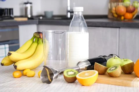Home kitchen with ripe fruit table and hand blender. Stock Photos