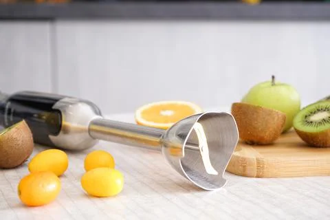 Home kitchen with ripe fruit table and hand blender, close-up. Stock Photos