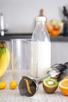 Home kitchen with ripe fruit table and hand blender. Vertically. Stock Photos