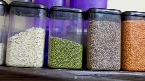 Home kitchen shelf displaying assorted dried beans and lentils in jars Stock Footage 320556623