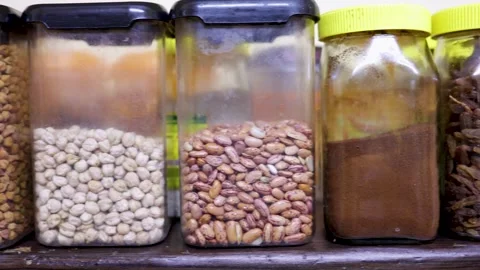 Home kitchen shelf displaying assorted dried beans and lentils in jars Stock Footage 320666807
