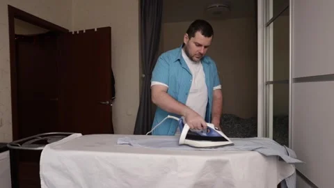Home Laundry Routine Featuring Man Ironing Shirt on Board, Housekeeping and.. Stock Footage 307758663