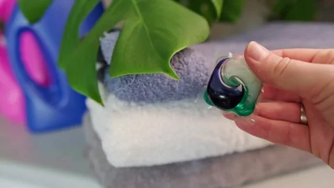 Home laundry with washing capsules, combining detergent, softener, and bleach in Stock Footage 295285985