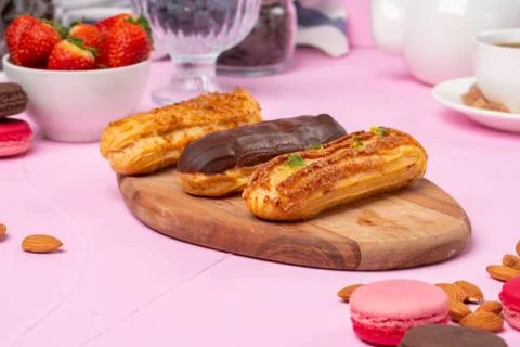Home made cake eclairs on pink table Stock Photos