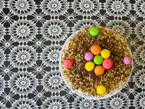 Home-made cake on a table covered with a beautiful tablecloth. Stock Photos