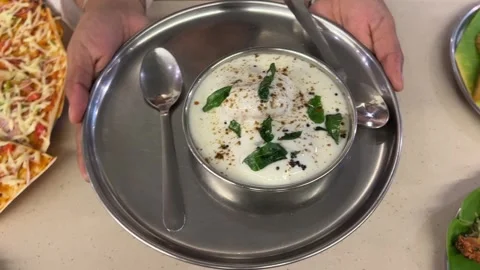 Home made dahi vada served with curry leaves in a steel plate in India. Stock-Footage 308100666