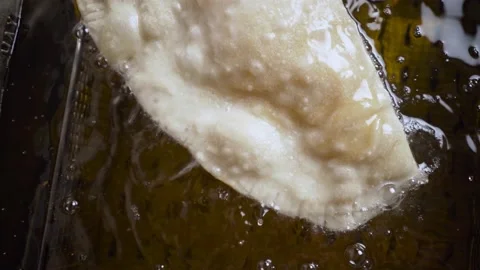 Home made fresh pie deep frying in olive oil. Video stock 189328703