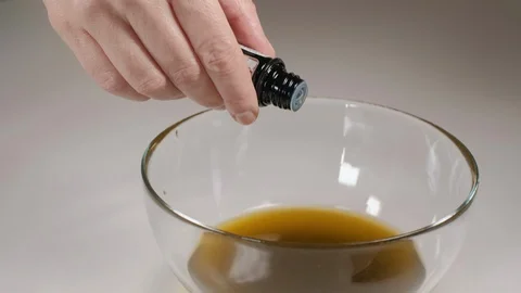 Home made ointment creating process. Adding geranium essential oil Stock-Footage 127711680