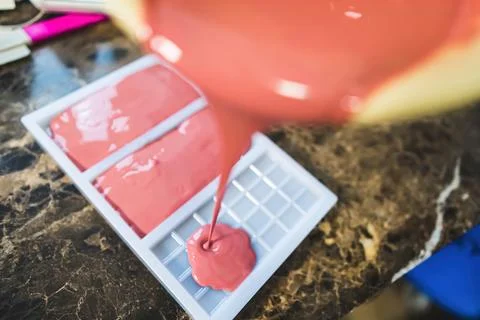 Home-made ruby chocolate bars. High angle view showing the process of pouring 库存照片