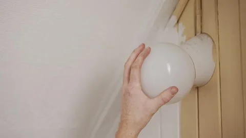 Home maintenance adjusting interior wall light Stock Footage 325843988