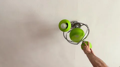 Home maintenance worker replacing ceiling light bulb Stock Footage 338190061