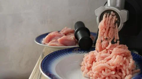 A home meat grinder in the process of grinding meat Stock Photos