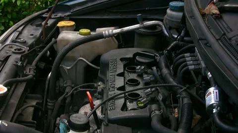 Home mechanic fitting a vacuum gauge to do engine cylinder compression test Stock Footage 59169814