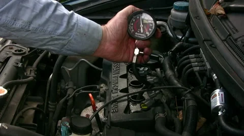 Home mechanic using vacuum gauge to show normal engine cylinder compression test Stock Footage 59169839