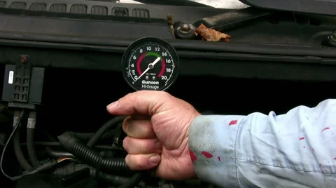 Home mechanic using vacuum gauge to do engine cylinder compresion test Stock Footage 59170064