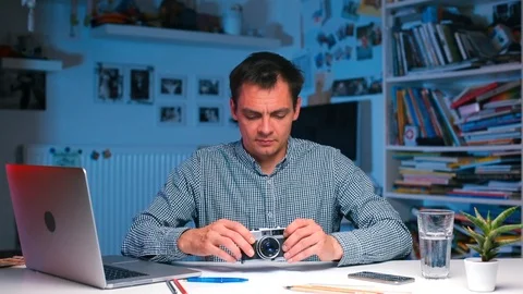 Home office COVID-19. Engineer is testing new camera, watching photos on laptop. Stock Footage 118067585