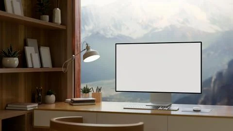 A home office features a computer mockup against the window with a view of .. Stock Photos