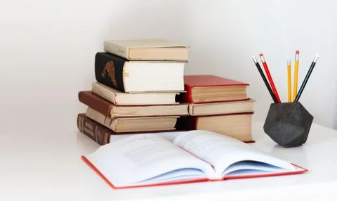 Home office: open textbook, notebook, stack of old books retro education back Stock Photos