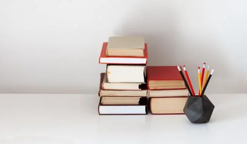 Home office: open textbook, notebook, stack of old books retro education back Stock Photos