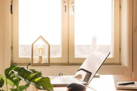 Home office setup on a table next to a window on a sunny day Stock Photos