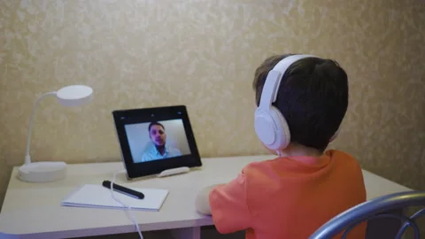 Home online learning. A boy in white headphones watches an online lesson Stock Footage 171416982
