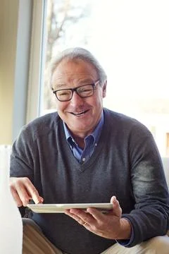 Home, portrait and old man with smile, tablet for online entertainment and .. Stock Photos
