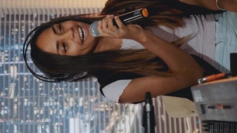 Home recording studio: multiracial pretty vocalist singing song into microphone Stock Footage 129879178