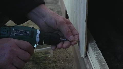 Home renovation. a carpenter using a power tool screws a self-tapping screw into Stock Footage 161834141
