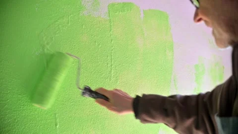 Home Renovation Painter Rolling Bright Green Paint Over Wall With Paint Roller Stock Footage 336043915