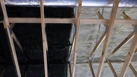 Home renovation process showing ceiling beams painted black over insulated Stock Footage 337492439