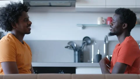 In a home setting, two young African men engage in a lively conversation. Stock Footage 279671478