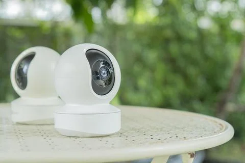 Home smart security camera on garden table. Surveillance tech for remote ac.. Stock Photos