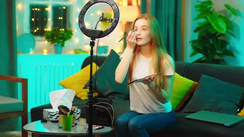At home on the sofa pretty looking lady beauty blogger using a smartphone and Stock-Footage 146468137