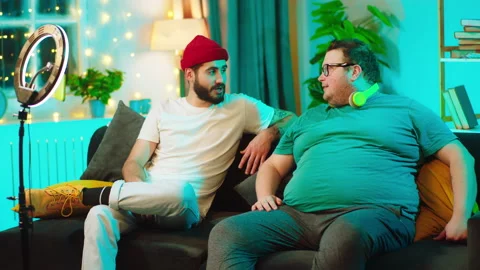 At home on the sofa two students guys have a friendly conversation one of the Stock Footage 146471804