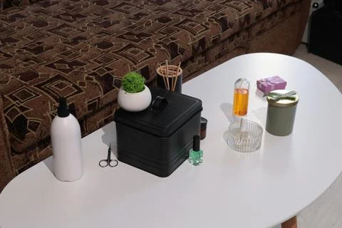 Home spa essentials arranged on a white table with a patterned sofa in the .. Stock Photos