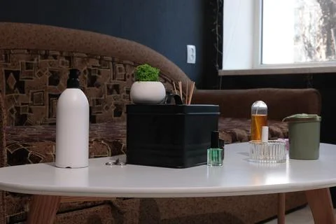 Home spa essentials arranged on a white table with a sofa in the background Stock Photos
