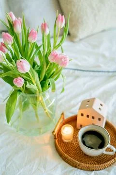 Home spring decor, bouquet of tulips in vase, hot coffee. Foto stock