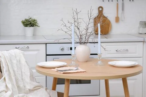 Home spring easter design in kitchen. Ceramic vase with spring branches, plates Foto stock