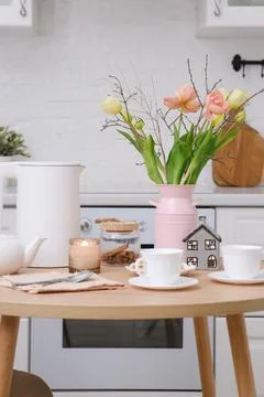 Home spring easter interior in kitchen. Pink vase with tulips and branches Foto stock