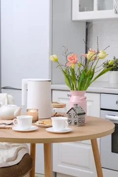 Home spring easter interior in kitchen. Pink vase with tulips and branches Foto stock