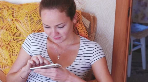 Home, technology and internet concept - smiling woman with smartphone sitting on Stock Footage 63909862