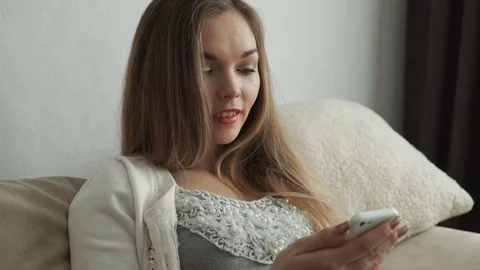Home, technology and internet concept - smiling woman sitting on the couch with Stock Footage 74438774