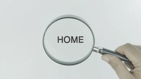 Home text or word highlighted by a magnifying glass in a hand on a white Stock Footage 303641937