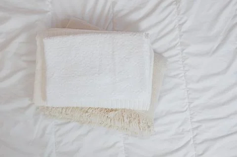 Home textiles Flatlay. A stack of towels lies on a white bed Stock Photos
