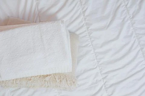 Home textiles Flatlay. A stack of towels lies on a white bed Stock Photos