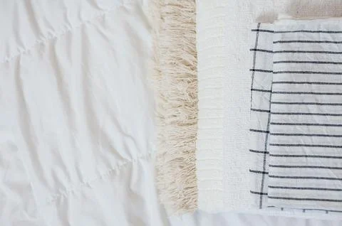 Home textiles Flatlay. A stack of towels lies on a white bed Stock Photos