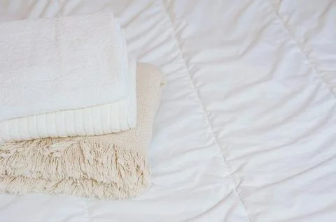 Home textiles. A stack of towels lies on a white bed Stock Photos
